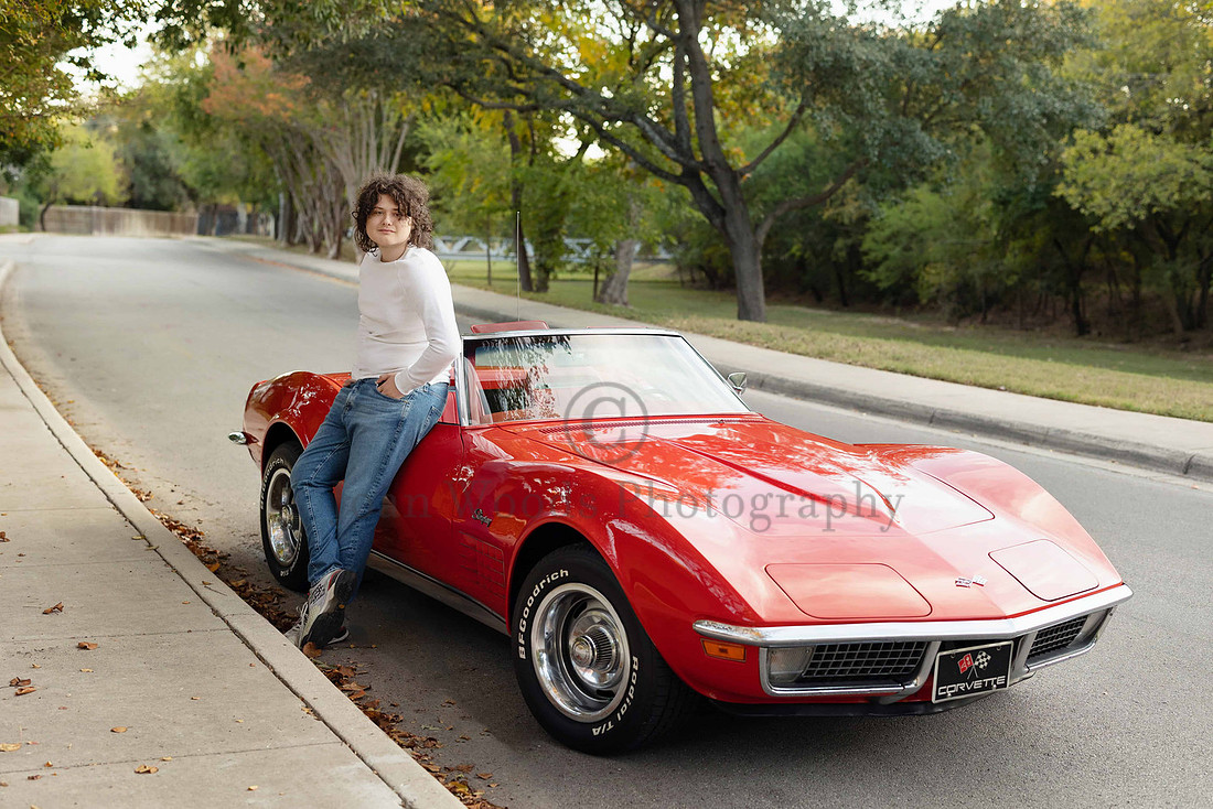 Senior guy leaning against a classic convertible corvette