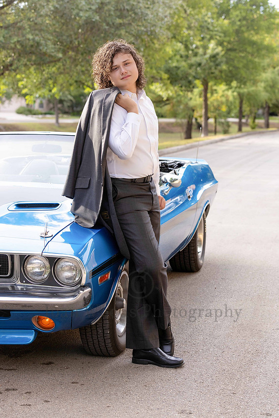 Senior guy in custom luxury suit against a convertible classic sports car  for gradutation portraits